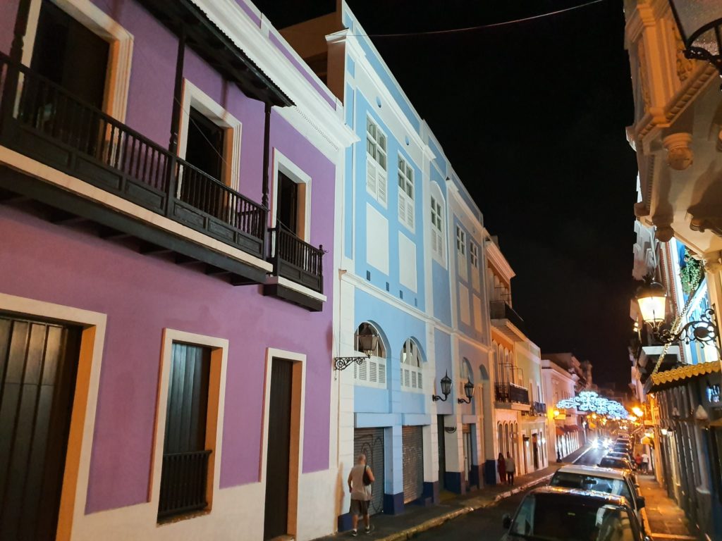 Stradă cu clădiri colorate, iluminată noaptea