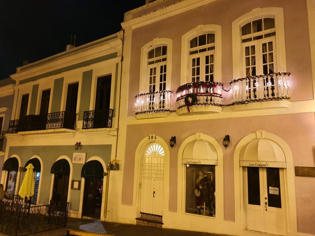 Fațadă cu ferestre și balcoane în lumină nocturnă