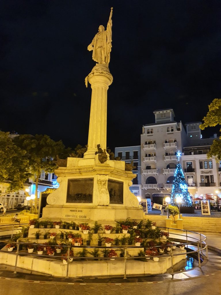 Coloană monumentală într-o piață iluminată noaptea