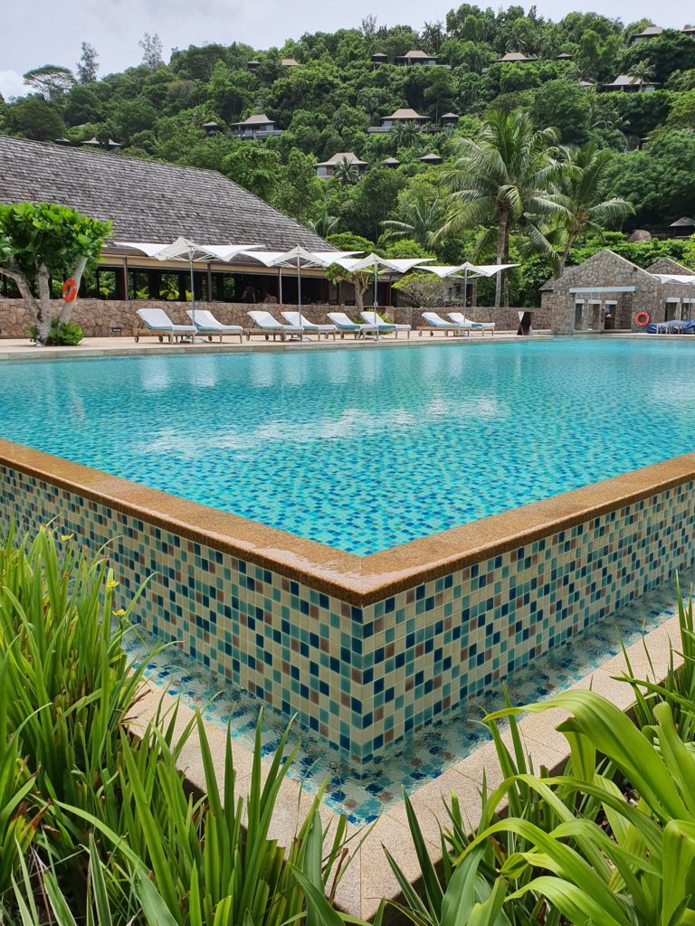 Piscină cu margine decorativă și clădiri în fundal