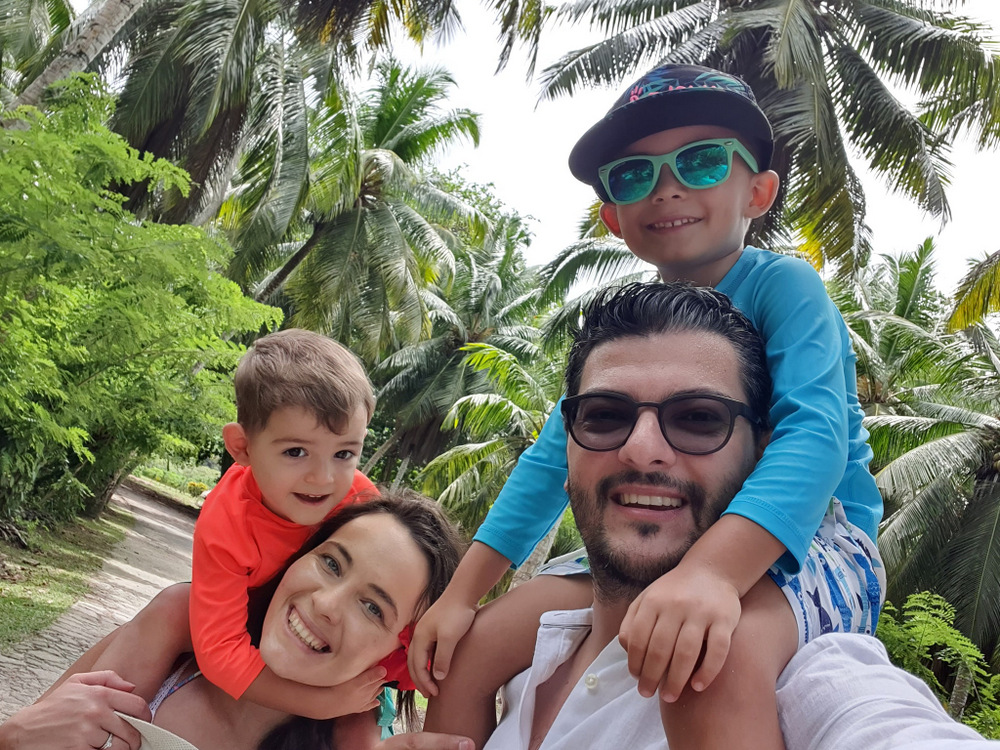 Familie cu copii în apropierea unor palmieri