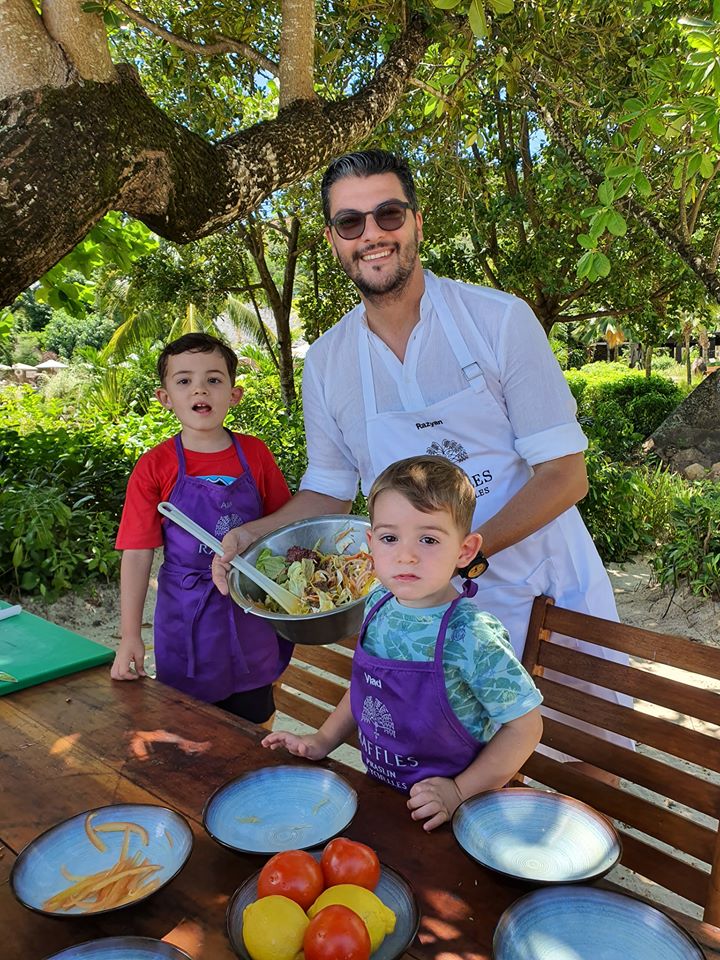 Bărbat și doi copii cu șorțuri lângă ingrediente pentru gătit.