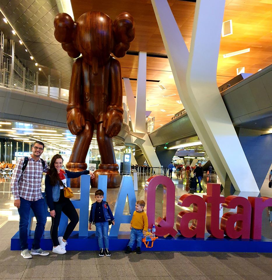 Familie lângă o sculptură uriașă și literele colorate Qatar.