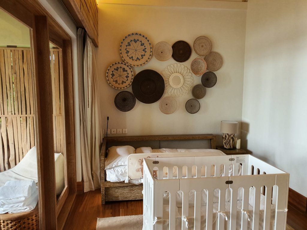Pătuț pentru bebeluși într-o cameră decorată cu coșuri împletite