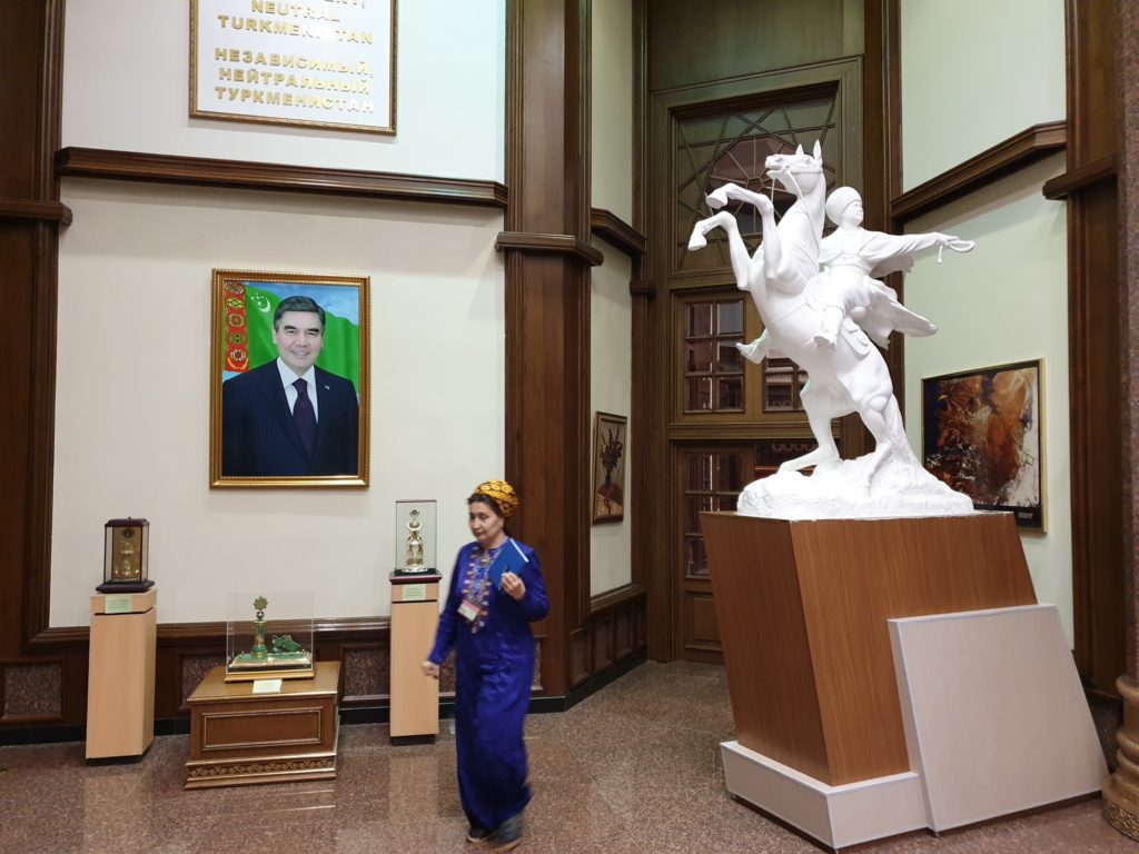 Femeie lângă o sculptură albă cu cai