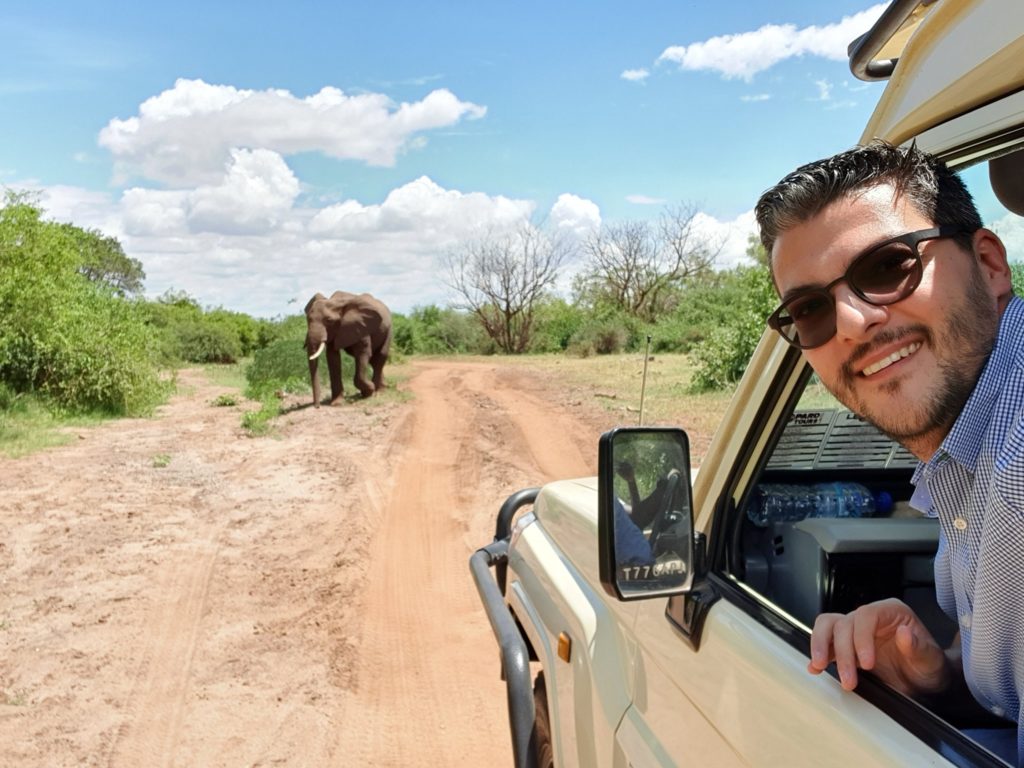 Bărbat într-un vehicul de safari, lângă un elefant
