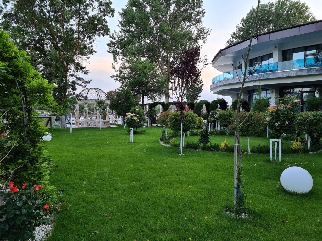Peluză cu arbori și corpuri sferice de iluminat