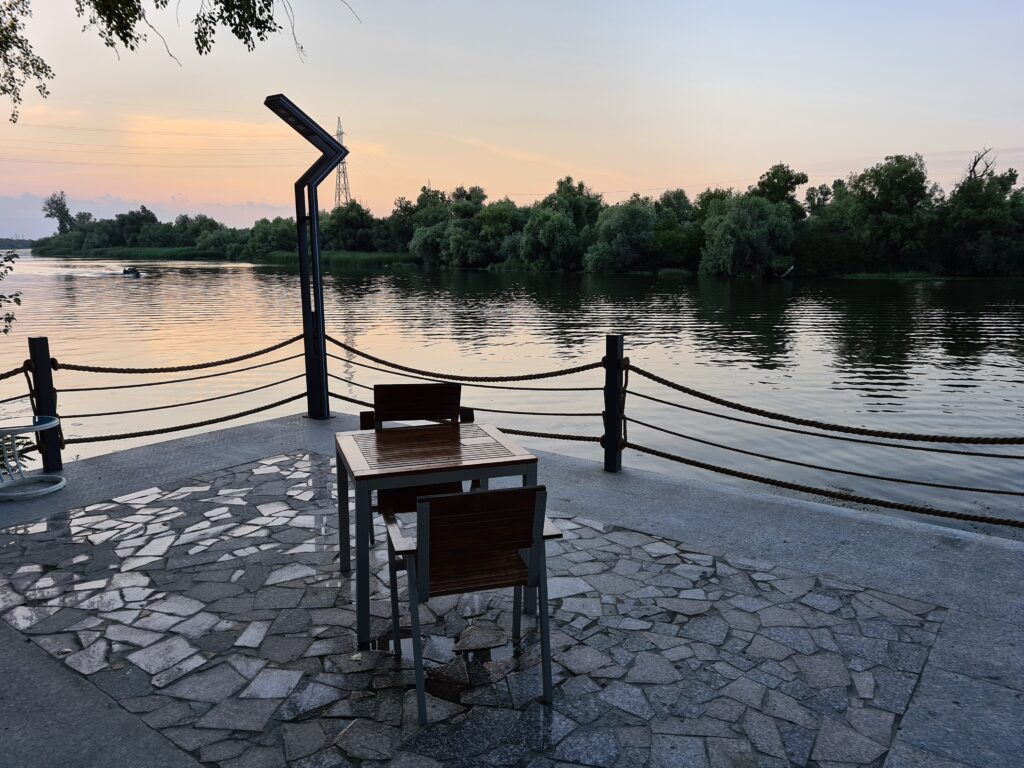 Masă și scaune pe o terasă la malul apei