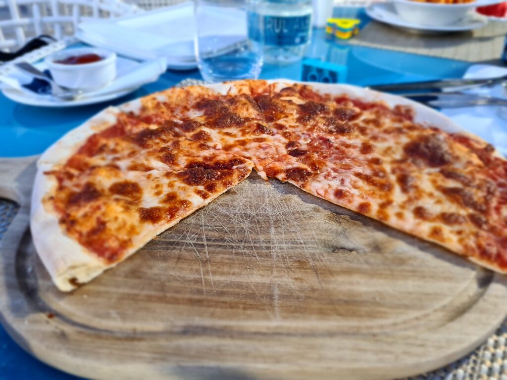 Pizza cu brânză pe un platou rotund din lemn