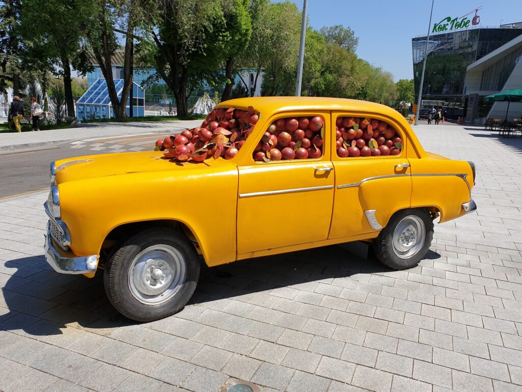 Automobil galben decorativ încărcat cu mere roșii