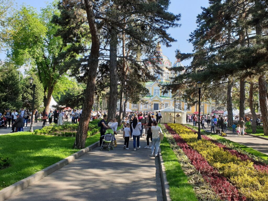 Alee de parc cu flori și oameni la plimbare