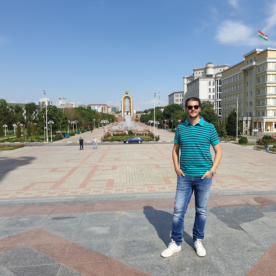 Bărbat într-o piață largă cu monument în fundal