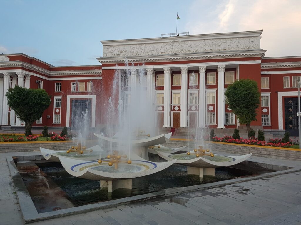 Fântână arteziană în fața unei clădiri cu coloane