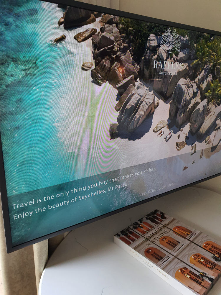 Ecran cu imagine de plajă tropicală deasupra unei console