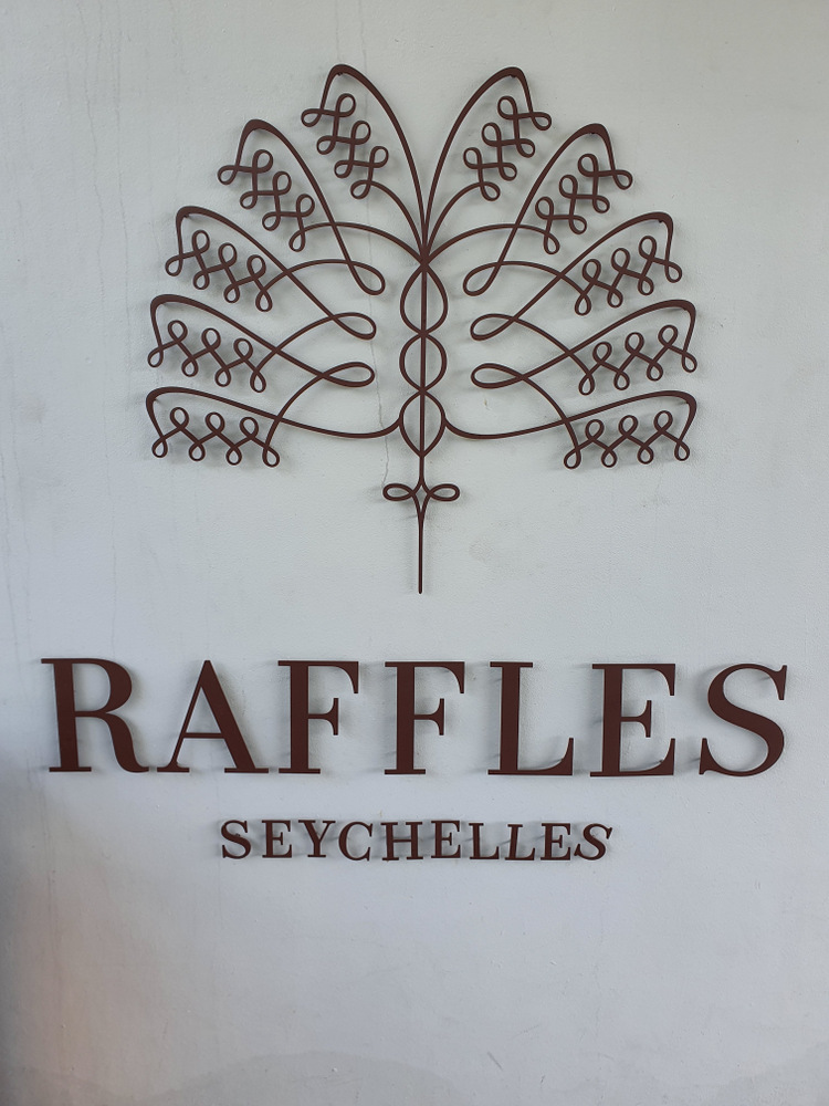Sigla Raffles Seychelles cu emblemă decorativă pe perete