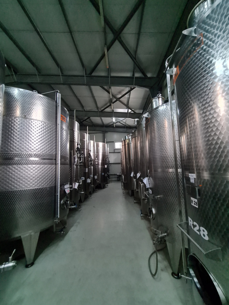 Culoar între rezervoare mari din inox într-o hală