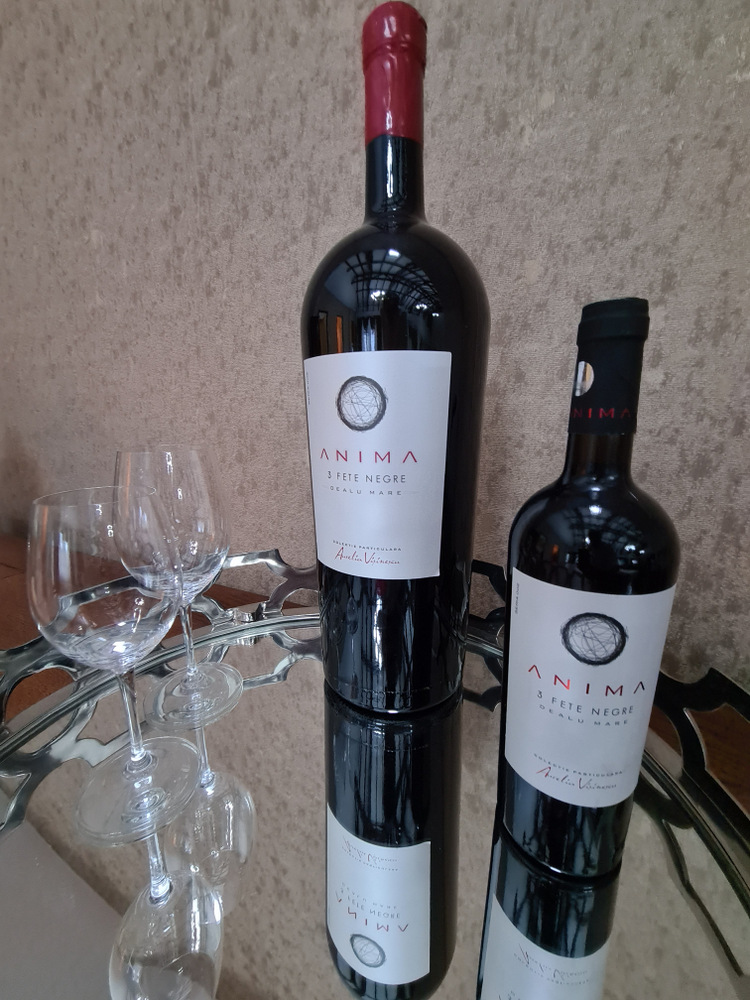Două sticle de vin alături de pahare pe masă