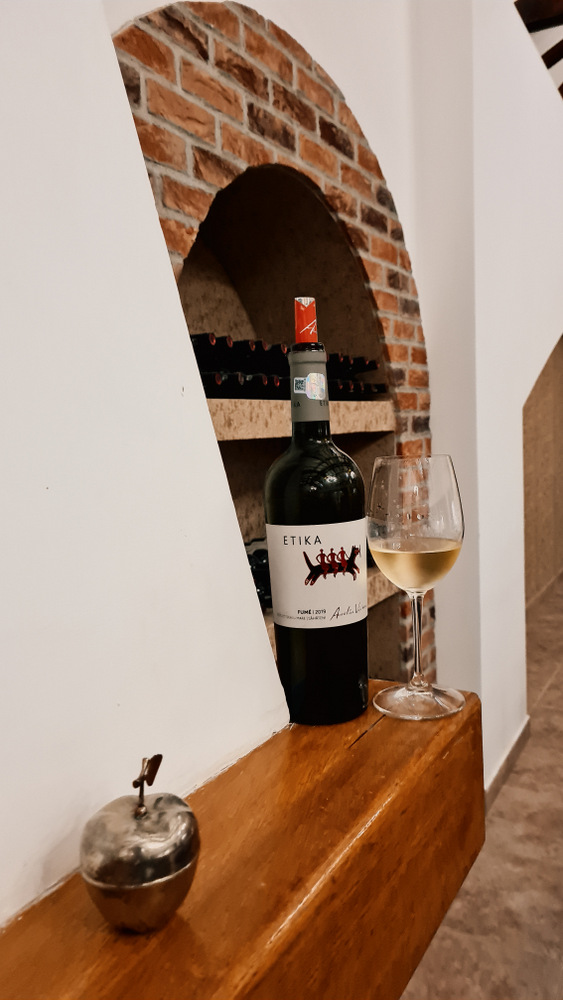 Sticlă de vin și pahar într-o nișă cu cărămidă