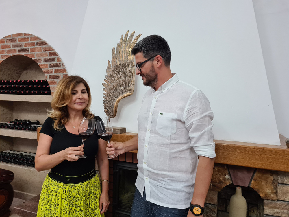 Femeie și bărbat cu pahare de vin într-o cramă