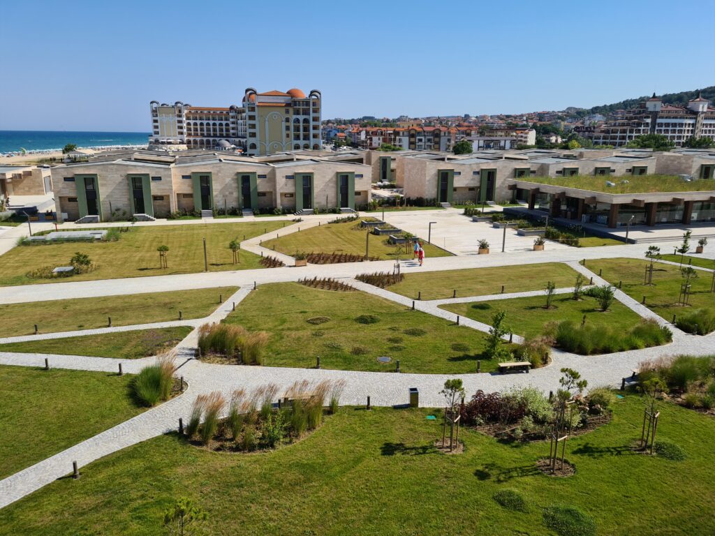 Complex hotelier cu grădini geometrice și mare în fundal
