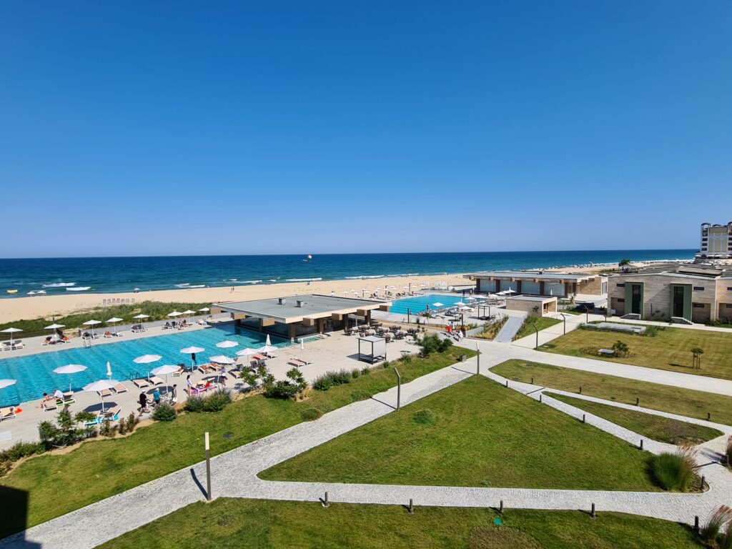 Piscine și alei verzi lângă o plajă cu nisip