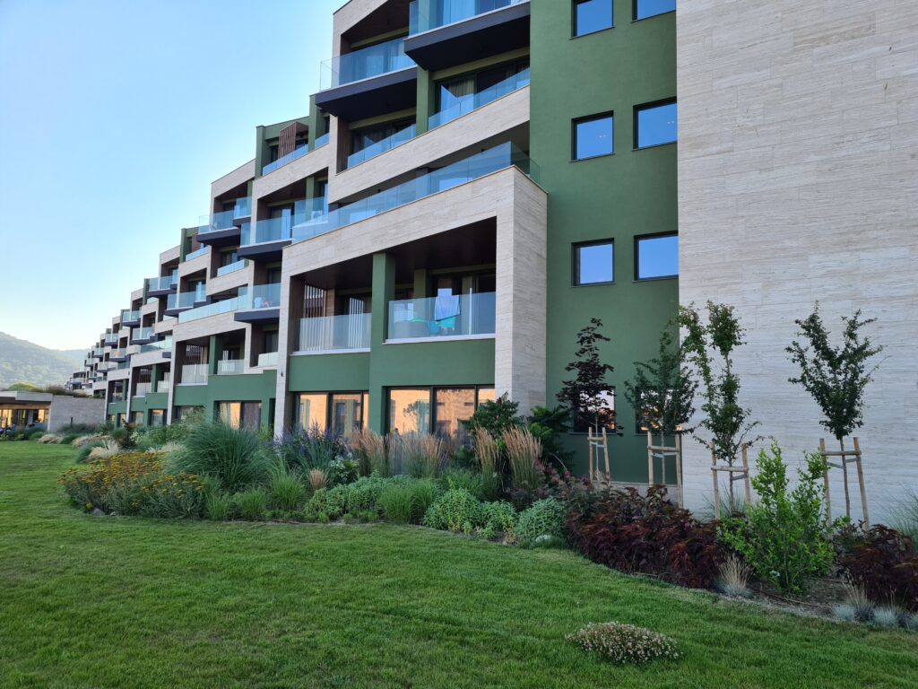 Fațada unei clădiri hoteliere moderne lângă o peluză verde