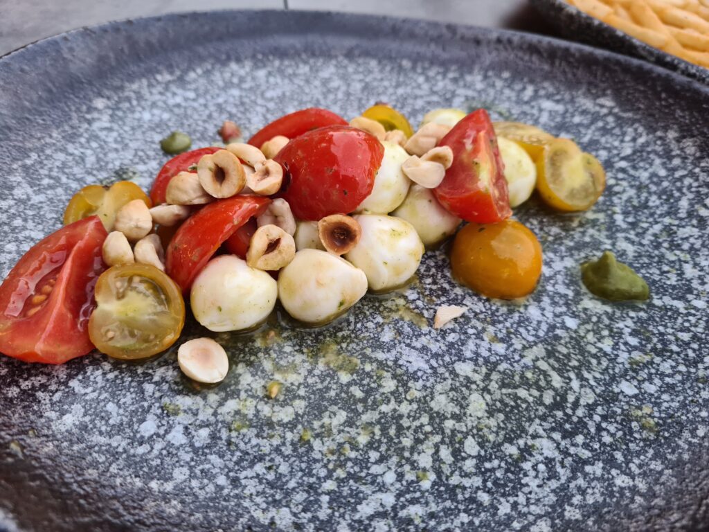 Salată cu roșii colorate și bucăți de brânză pe farfurie
