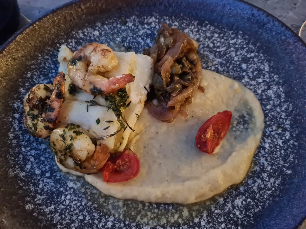 Fructe de mare cu piure și roșii pe farfurie