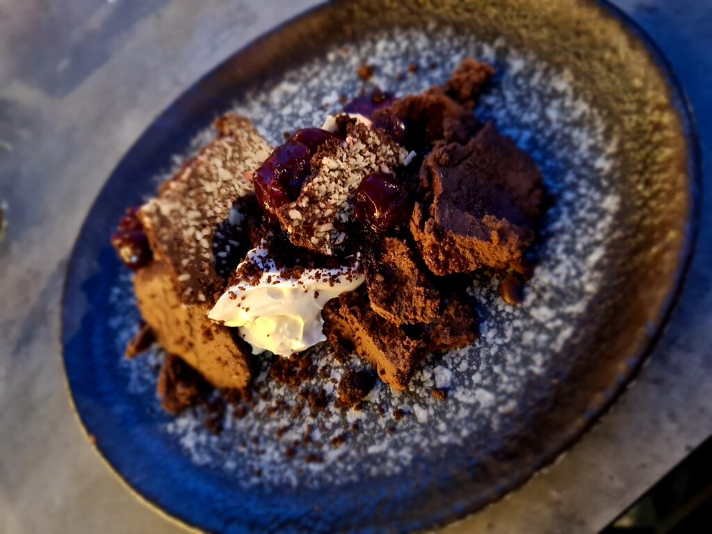 Desert presărat cu cacao, servit pe o farfurie închisă