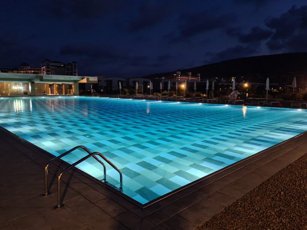 Piscină exterioară iluminată în albastru pe timpul nopții