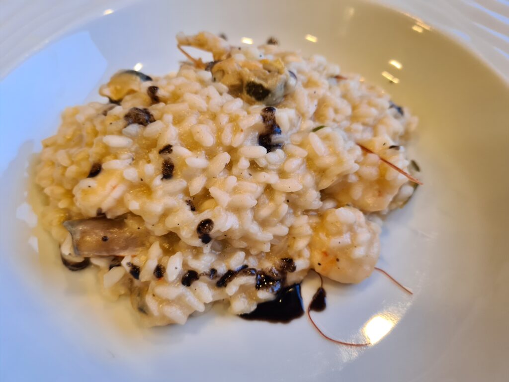 Risotto cremos presărat cu brânză rasă într-o farfurie albă