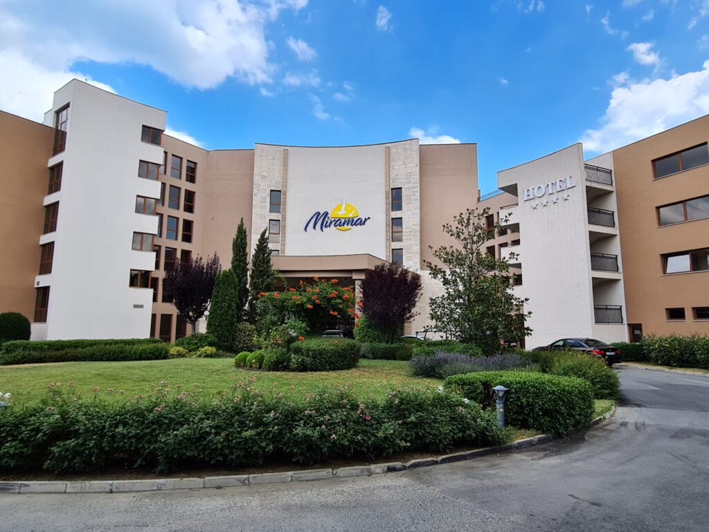 Fațada hotelului Miramar, cu peluză și arbuști în față