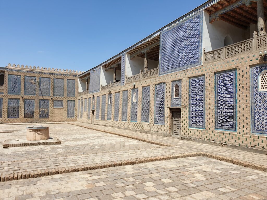 Curte pavată înconjurată de galerii cu ceramică albastră