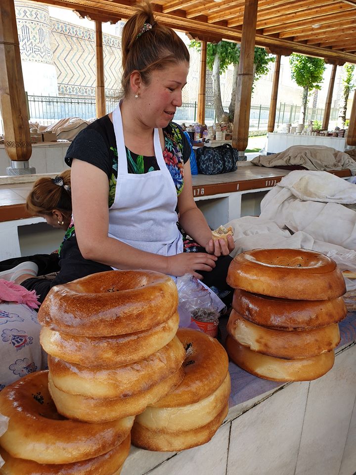 Vânzătoare lângă teancuri de pâini rotunde la tarabă