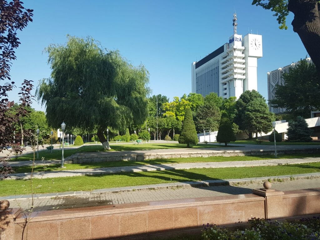Parc urban cu peluze și clădire înaltă în fundal