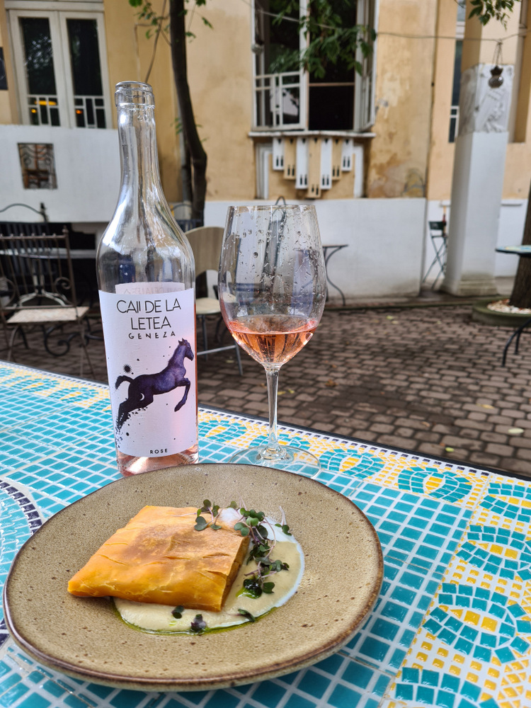 Preparat dreptunghiular rumenit lângă sticlă de vin și pahare pe masă.