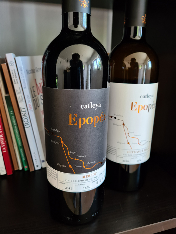 Două sticle de vin Catleya Epopee, fotografiate lângă cărți.