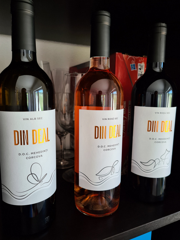 Trei sticle de vin cu etichete albe și inscripții portocalii.