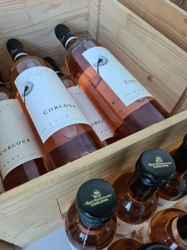 Sticle de vin și borcănașe așezate într-o cutie de lemn.