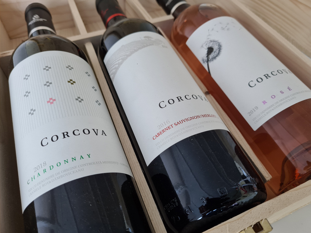 Sticle de vin Corcova cu etichete albe într-o cutie de lemn.