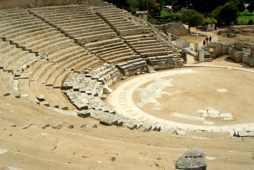 Teatru antic cu gradene semicirculare din piatră și arenă centrală.