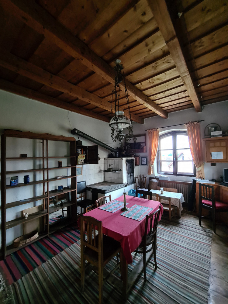 Cameră rustică cu masă acoperită și rafturi din lemn