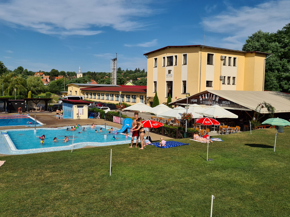 Clădire galbenă lângă piscină și peluză cu umbrele