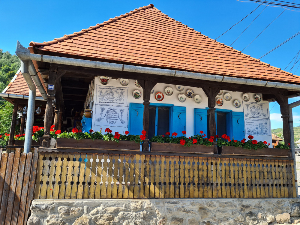 Casă tradițională cu prispă și ornamente colorate