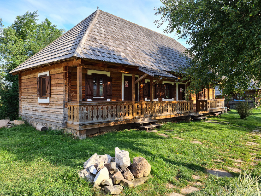 Casă de lemn cu prispă, într-o grădină verde