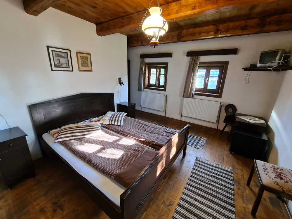 Dormitor rustic cu pat dublu și tavan din lemn