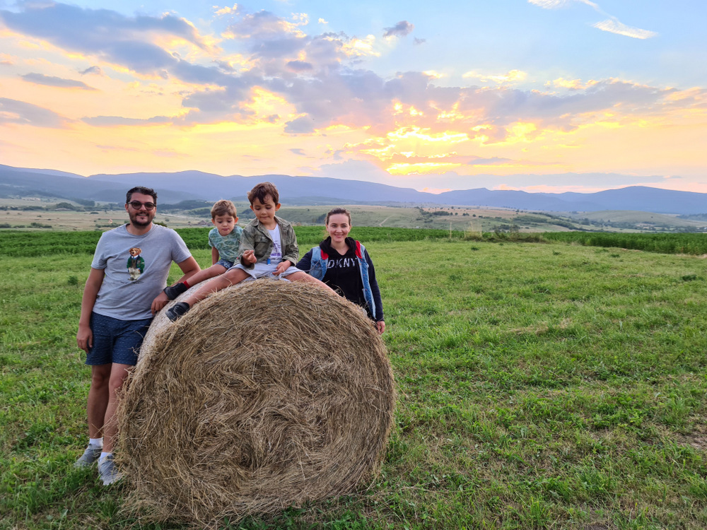 Grup lângă un balot de fân, într-o pajiște