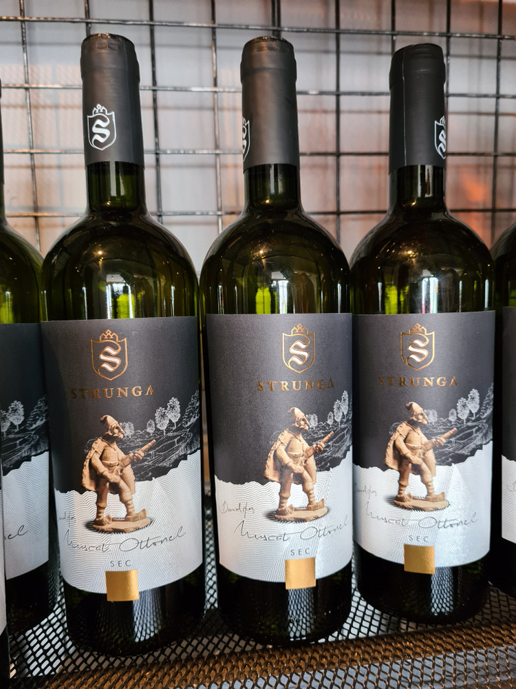 Trei sticle de vin cu etichete negre ilustrate