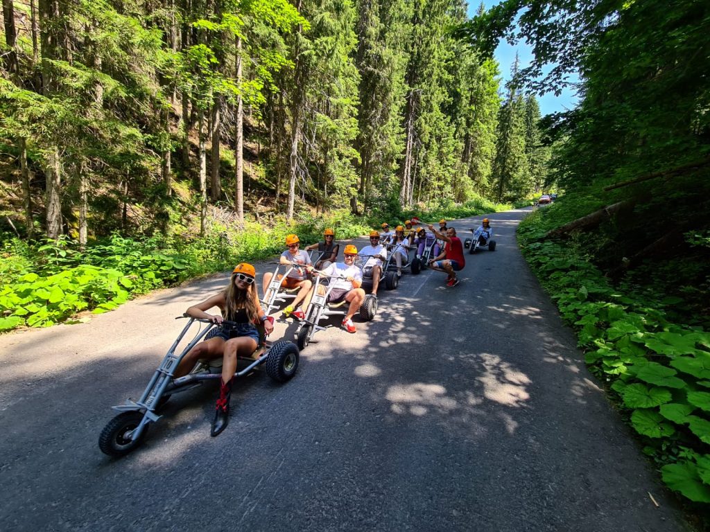 Grup pe tricicluri joase pe un drum prin pădure