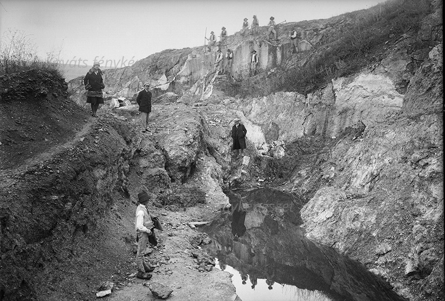 Fotografie alb-negru cu persoane într-o carieră de piatră